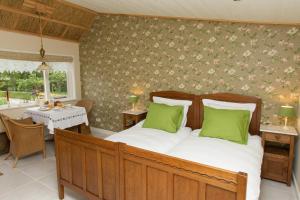 Un dormitorio con una cama con almohadas verdes y una mesa. en Bed And Breakfast Rodenberg en Driebergen