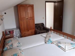 a bedroom with a bed and a chair at Topalovi Guest House in Chernomorets