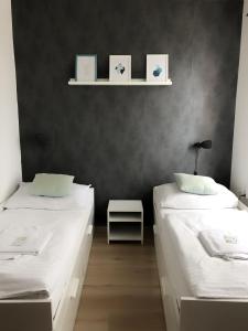 2 camas en una habitación con paredes negras en Hotel Gregor, en Modřice