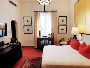a hotel room with a bed and a living room at Rachamankha Hotel in Chiang Mai