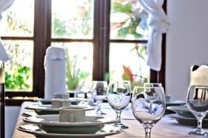 a table with plates and wine glasses on it at Moradas de Israel - Rede Tonziro in Porto Seguro +8 photos