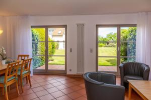 a living room with a table and chairs and sliding glass doors at Ferienwohnung Traumurlaub in Dewichow