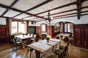 a dining room with tables and chairs and windows at Hotel Krone in Dornbirn