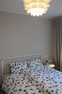 a bedroom with a bed with a blue and white comforter at Apartment Anna in Saldus