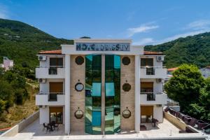 a hotel with a sign on top of a building at Hotel Odissey Jaz in Budva