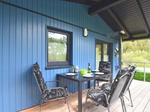 a patio with a table and chairs on a blue wall at holiday home in G ntersberge Harz with wood stove in Harzgerode