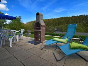 a group of chairs and a fireplace on a patio at holiday home in G ntersberge Harz with wood stove in Harzgerode