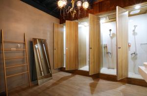 a bathroom with four shower stalls and a sink at Liuqiu Backpackers Hostel in Xiaoliuqiu