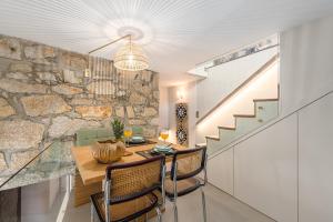 a dining room with a table and a stone wall at Victoria Project - Houses - Private Parking in Porto