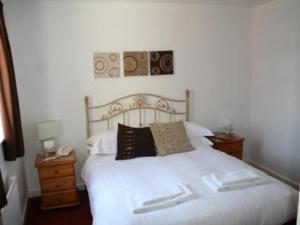 um quarto com uma cama branca e 2 almofadas em Beverley Inn & Hotel em Edenthorpe