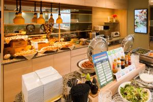 a buffet line in a restaurant with food at Super Hotel Tokyo JR Shinkoiwa in Tokyo