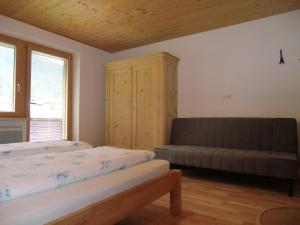 ein Schlafzimmer mit einem Bett und einem Sofa in der Unterkunft Ferienwohnung Annelies 379 in Mellau