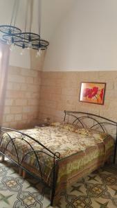 un lit dans une chambre avec un tableau sur le mur dans l'établissement La terrazza sul castello, à Palmariggi