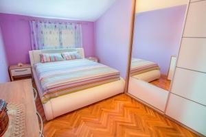 a small bedroom with a bed and a mirror at Luxury House Petrovic - Vranjina Skadar Lake in Podgorica