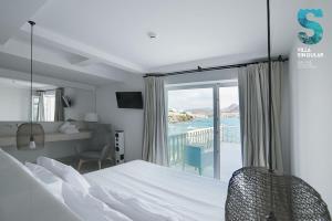 a bedroom with a bed and a view of the ocean at Villa Singular in San José