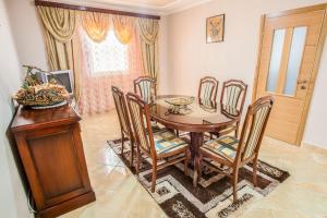Luxury House Petrovic - Vranjina Skadar Lake في بودغوريتسا: غرفة طعام مع طاولة وكراسي خشبية