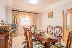 ein Esszimmer mit einem Tisch, Stühlen und einem TV in der Unterkunft Luxury House Petrovic - Vranjina Skadar Lake in Podgorica