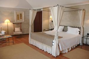 um quarto com uma cama de dossel e uma cadeira em Pousada Convento de Belmonte em Belmonte