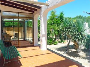 a porch of a house with a green bench at Holiday Home Marinada by Interhome in L'Ampolla