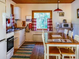 uma cozinha com uma mesa de madeira e uma sala de jantar em Holiday Home Isokoskelo 5 by Interhome em Strandby