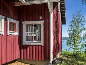 ein rotes Haus mit einem Fenster auf der Seite in der Unterkunft Holiday Home Punasotka 2 by Interhome in Strandby