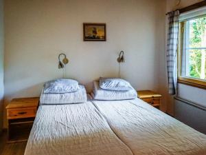 um quarto com uma cama com duas almofadas e uma janela em Holiday Home Isokoskelo 5 by Interhome em Strandby