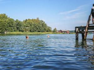 twee kinderen zwemmen in het water bij een dok bij Holiday Home Punasotka 2 by Interhome in Strandby