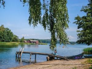 a person sitting on a dock on a lake at Holiday Home Merimetso 6 by Interhome in Strandby