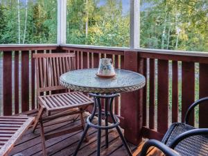 a table on a porch with two chairs and a tea pot at Holiday Home Merimetso 6 by Interhome in Strandby