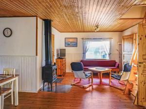 uma sala de estar com um sofá e um fogão a lenha em Holiday Home Isokoskelo 5 by Interhome em Strandby