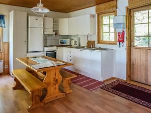 a kitchen with a wooden table and a wooden floor at Holiday Home Rantasipi 1 by Interhome in Strandby