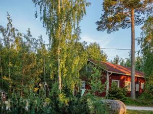 a red house with a red roof and trees at Holiday Home Merimetso 6 by Interhome in Strandby