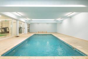 an empty swimming pool in a room with a bench in it at Oceania Bay Village in Pyla