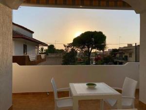 a table and chairs on a balcony with the sunset at Salento Sunset House in Pulsano