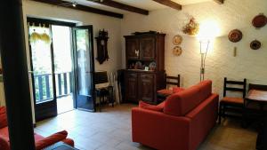 a living room with a red couch and a table at La Segheria in Pragelato