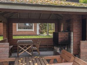 un patio con mesa, sillas y chimenea en Holiday Home Jukola by Interhome, en Ruottila