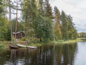 una cabaña a orillas de un lago con dos barcos en Holiday Home Jukola by Interhome, en Ruottila