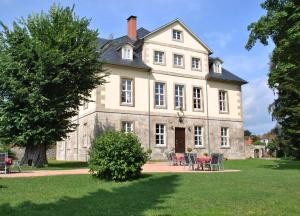 an old house with chairs and tables in front of it at Jagdschloß Walkenried in Walkenried