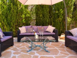 Balcon del MarにあるVilla Karima by Interhomeの紫色の家具と傘が備わるパティオ