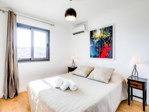 a white bedroom with a bed and a window at Apartment Résidence Cita di Sali-7 by Interhome in Porto-Vecchio