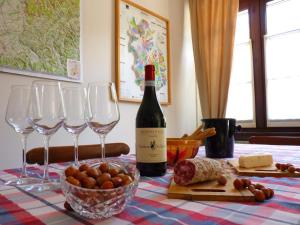 una botella de vino y copas de vino en una mesa en Agriturismo Viticcio, en La Morra