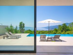 einen Blick auf den Pool durch die Glastüren eines Hauses in der Unterkunft Villa Minimal by Interhome in Kastav