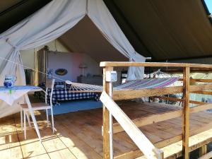 a tent with a bed and a table in it at Agriturismo Glamping Erbe Matte in SantʼAntìoco