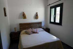 um quarto com uma cama com duas almofadas e uma janela em Baglio La Luna - B&B em San Vito lo Capo