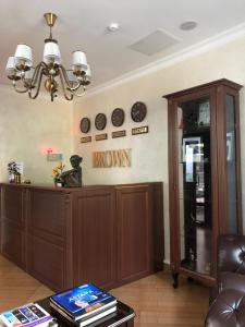 a living room with a brown cabinet and clocks on the wall at Brown Hotel in Astana