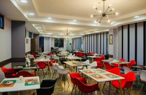 a restaurant with tables and chairs and a chandelier at Resolute Shekvetili Hotel in Shekhvetili