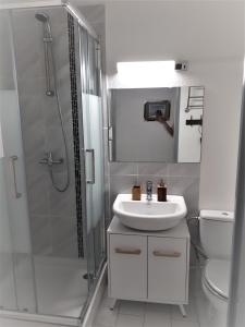 a white bathroom with a sink and a shower at Appartement Carnon Plage in Carnon-Plage