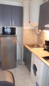 eine Küche mit einer Waschmaschine und einem Waschbecken in der Unterkunft Appartement Carnon Plage in Carnon-Plage