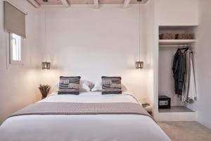 a bedroom with a large white bed with two pillows at Naxian Utopia | Luxury Villas & Suites in Stelida +106 photos