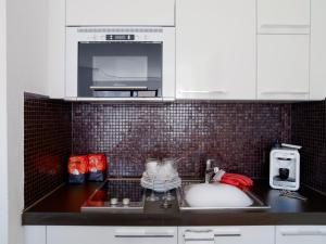 a kitchen counter with a sink and a microwave at VISIONAPARTMENTS Rue Caroline - self check-in in Lausanne